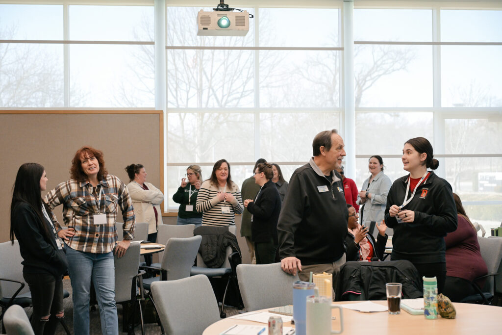 Attendees at the conference spread out in the room and talking.